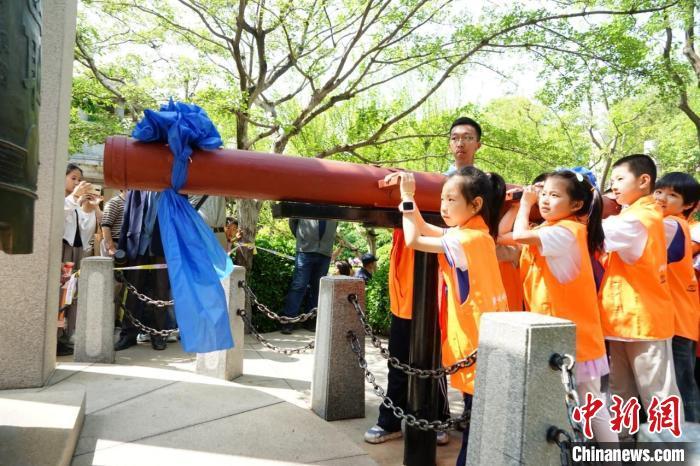 5月3日，“五三惨案”96周年纪念活动在位于济南市的趵突泉景区内举行。图为参与纪念活动的学生共同敲响警钟。(天下第一泉风景区供图)