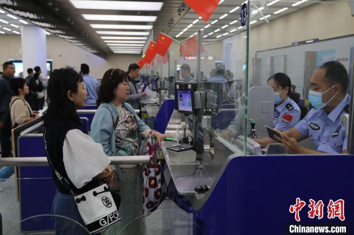 5月4日，青岛机场出入境边防检查站民警为旅客办理通关手续。(资料图)徐哲 摄