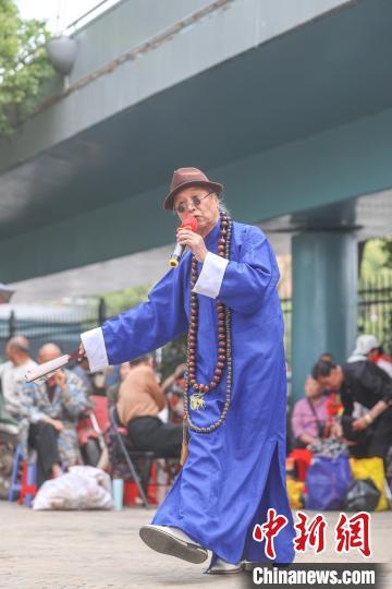 图为八一乐团的一位歌手在唱歌。每次乐团负责人在微信群里通知了表演时间和地点，有空的乐团成员就会携带各自的演出设备和服饰赶到演出地点，大家都很积极热情。刘力鑫摄