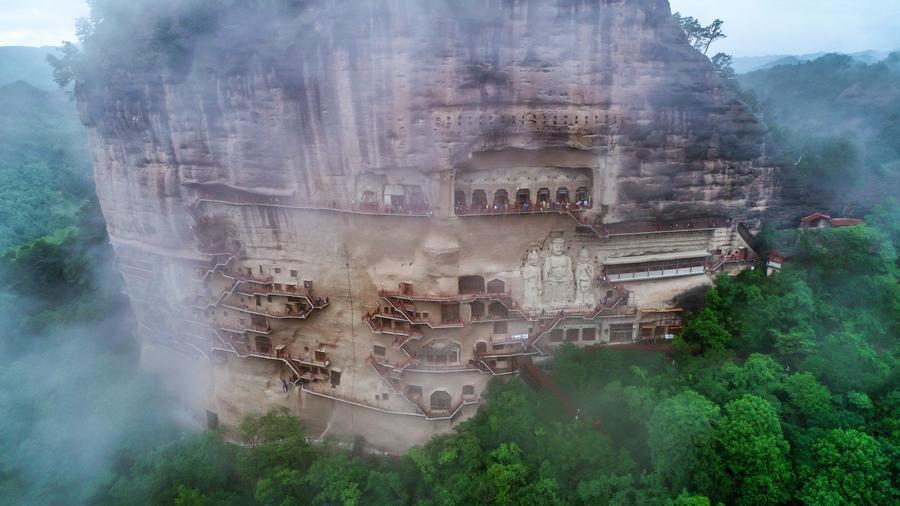 这是2023年5月31日在甘肃省天水市拍摄的烟雨笼罩下的麦积山石窟（无人机照片）　新华社记者　郎兵兵　摄