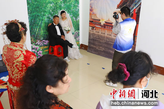 志愿者为老年夫妻拍摄婚纱照。 熊华明 摄