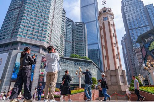5月5日，渝中区解放碑步行街，游客在解放碑前打卡拍照。记者 李雨恒 摄