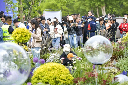 五一假期首日，众多游客前来欣赏“莫奈花园”，门口还排起了长队。来源：济南报业全媒体