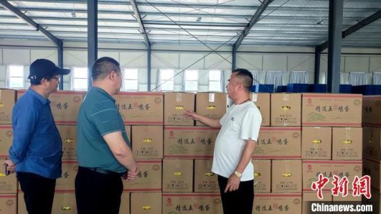 图为德安县吴山镇蛋鸡养殖场，负责人王军(右一)正在介绍鸡蛋产品。巫发阳摄