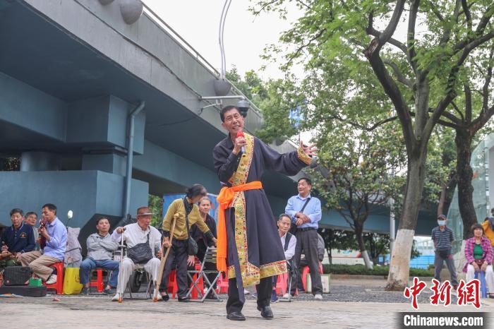 图为八一乐团的一位歌手身着传统服饰在唱歌。八一乐团里有众多歌手，大家唱歌曲风格也各不相同，但每次表演时，团长都会要求到场的每个歌手都要拿起话筒唱歌。刘力鑫摄