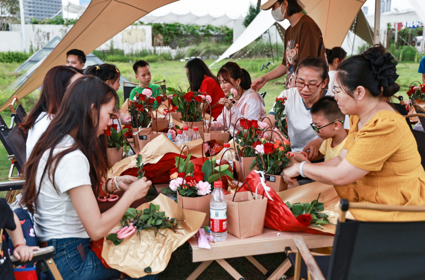 活动现场，人们在花艺老师指导下学习插花手艺。