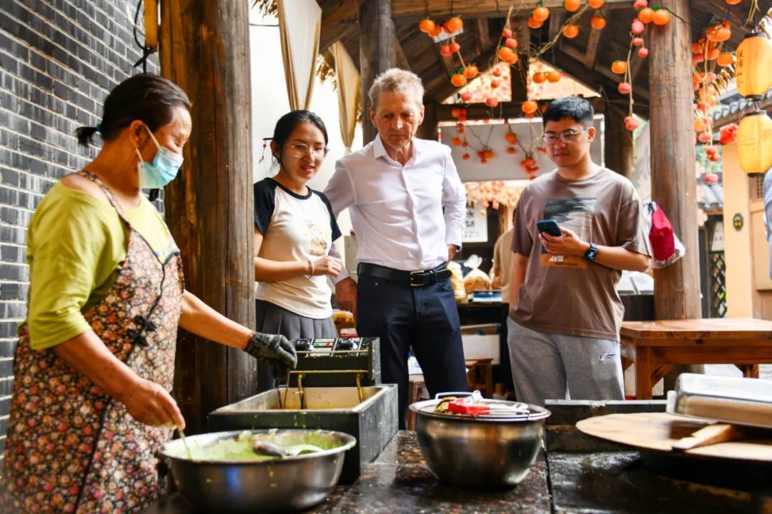 法国游客在客家古城了解客家美食铁勺粄的制作过程。