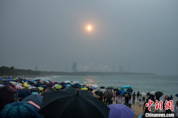 5月3日17时27分，嫦娥六号探测器由长征五号遥八运载火箭在中国文昌航天发射场成功发射。图为民众冒雨观看火箭发射升空。中新社记者 骆云飞 摄