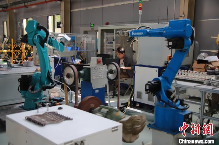 图为重庆华数机器人有限公司测试车间里工程师正在调试机器人。马佳欣 摄