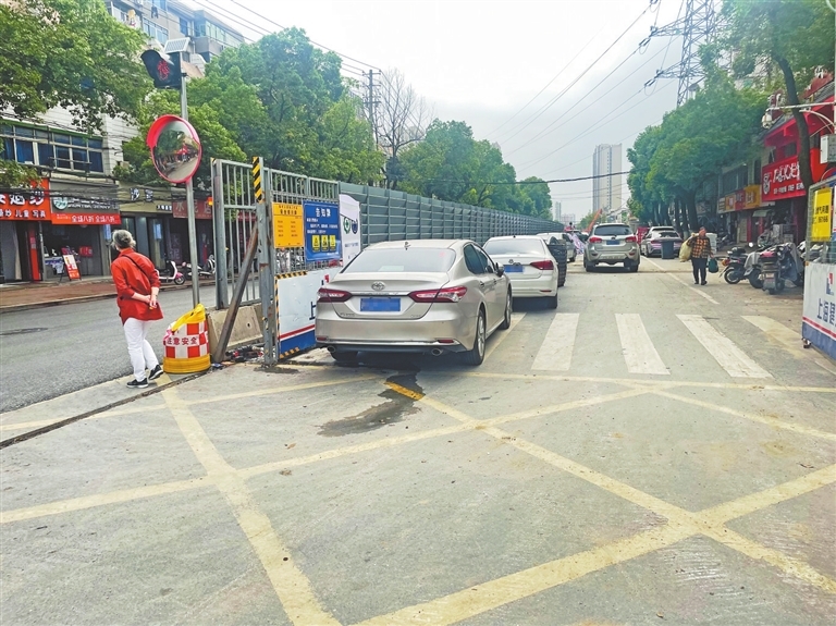 占据了半幅路面的围挡内侧成了“停车场”。 江西日报全媒体记者 蔡颖辉摄