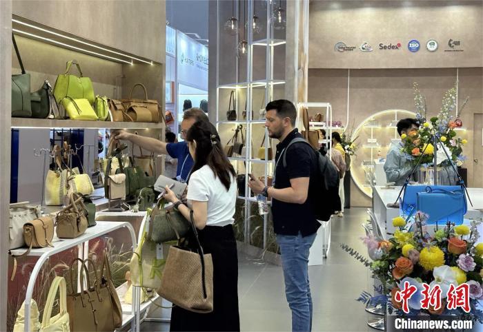 5月4日，中国企业在第135届广交会展出的包包吸引境外采购商咨询。中新社记者 程景伟 摄