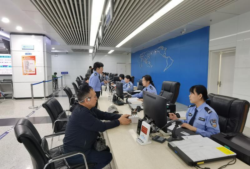 图为西安市出入境管理接待大厅的工作人员正在为群众办理相关业务