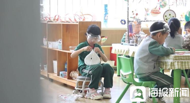 青蓝幼儿园一位小朋友沉迷于手工钩花。