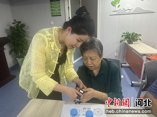 工作人员指导老人使用智慧手表。 王娟 摄