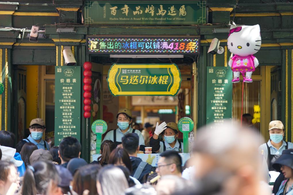 5月1日，在哈尔滨中央大街上，游客排队购买马迭尔冰棍。新华社发