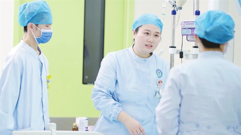 周丽（左二）与护士分享护理经验。