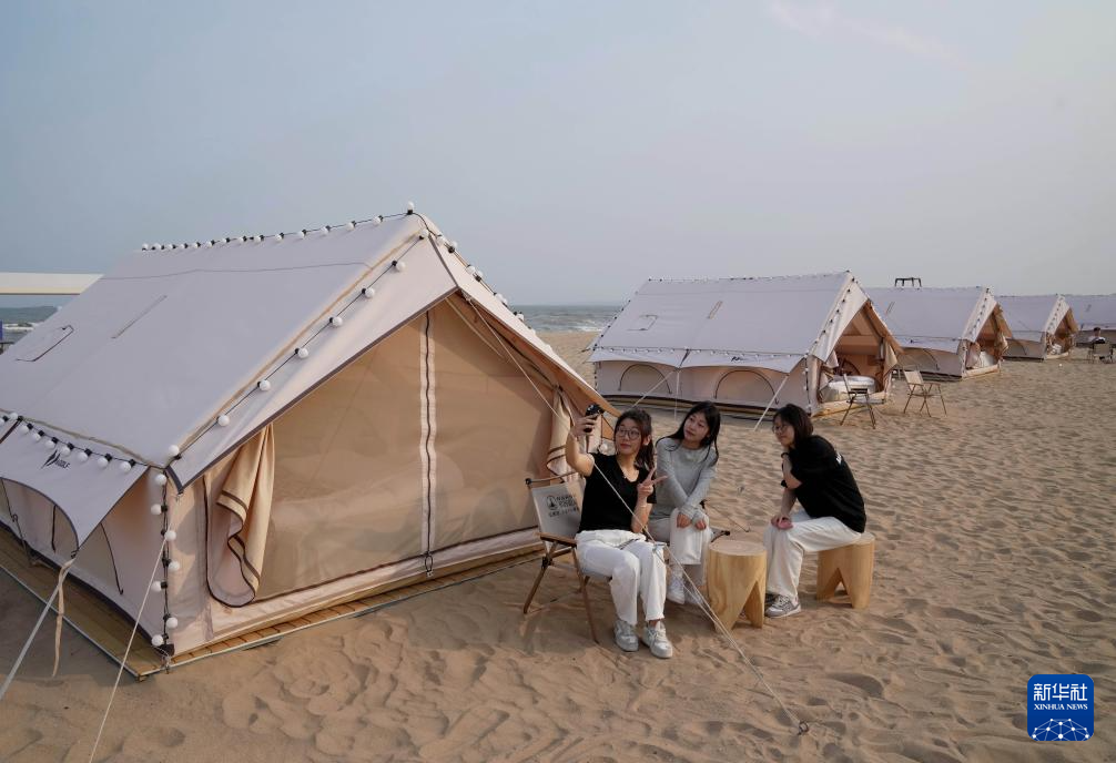 5月10日，游客在秦皇岛市金梦海湾的沙滩帐篷营地休闲。