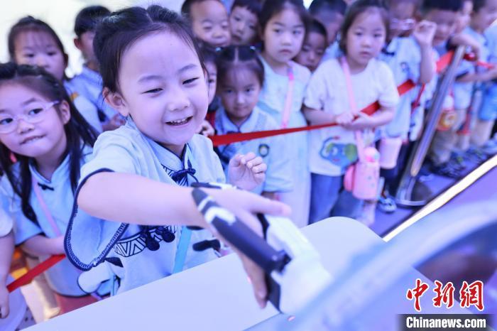 5月16日,在位于河北省邯郸市邯山区的邯郸人工智能教育基地,小朋友们正在体验与机器人握手。 李昊 摄