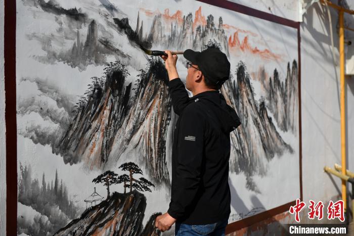 5月13日，深州市王家井镇垣里村，李培芝为巨幅墙体画着色。刘娟 摄