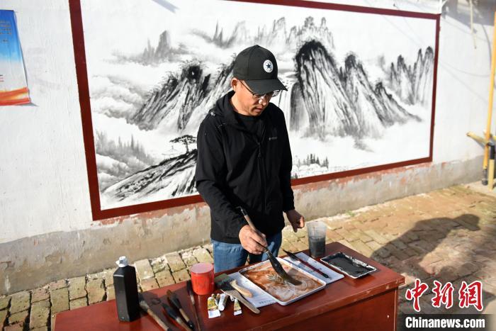 5月13日，深州市王家井镇垣里村，李培芝正在调制绘画所用颜料。刘娟 摄