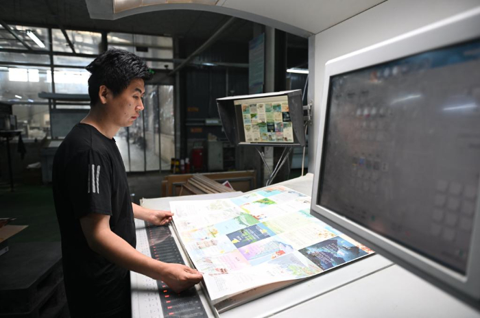 5月11日，河北省涿州市一家图书印刷企业的工人在印刷车间内工作。