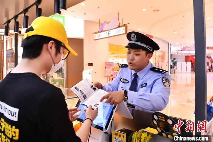 5月11日，烟台市公安局芝罘分局经侦大队民警进入商场，向商户普及防范知识。梁维涛 摄