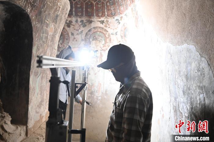 图为昌马石窟内工作人员进行造像和壁画数据检测复核工作　李亚龙　摄
