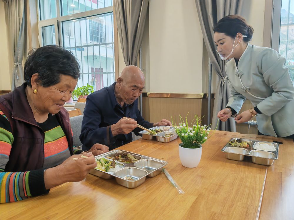 曾文方(右一)在给老人提供餐饮服务 新华社记者 崔翰超 摄