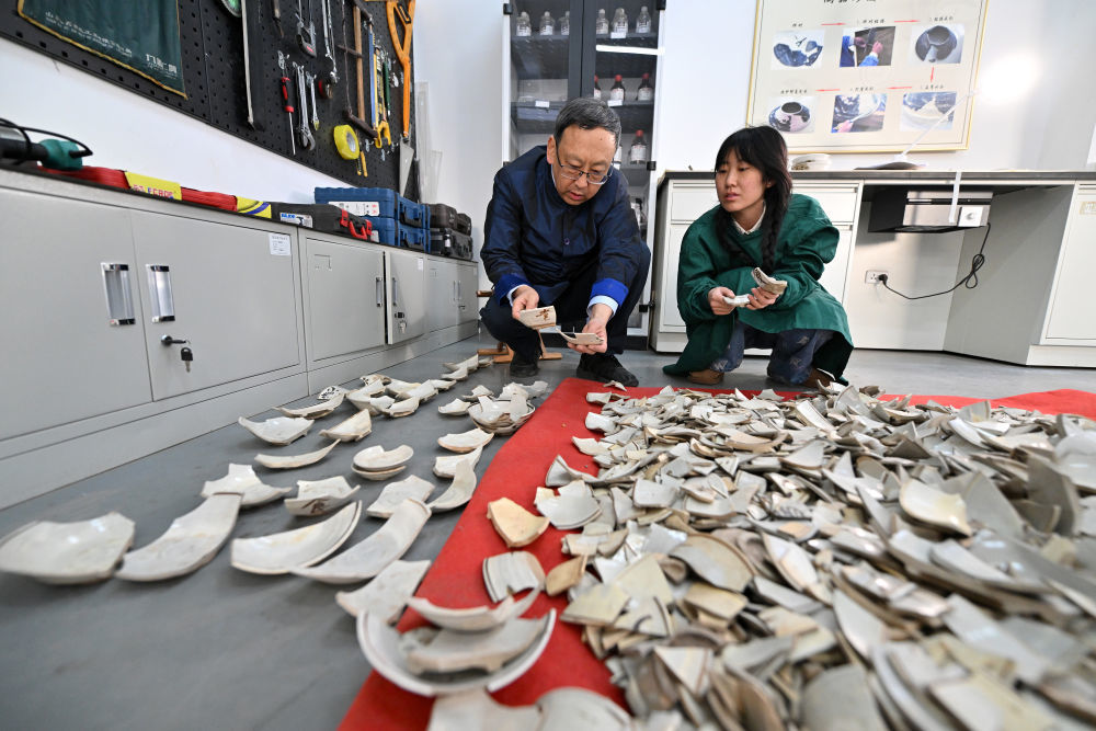 2024年2月25日，在山西云冈研究院可移动文物修复室，云冈研究院院长杭侃（左）和同事交流瓷器修复方案。