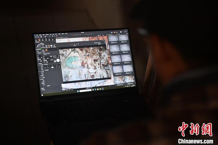 图为昌马石窟内工作人员进行造像和壁画数据检测复核工作　李亚龙　摄