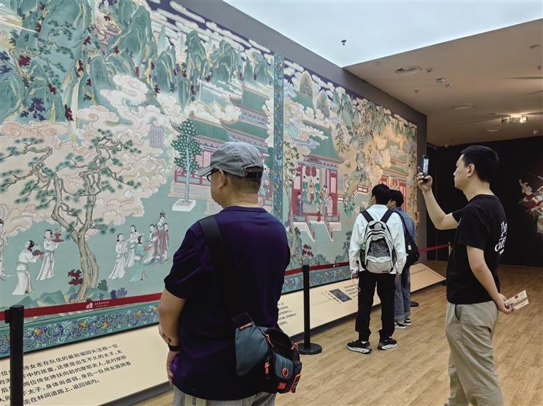 市民在甘肃简牍博物馆“小故宫 大气象”瞿昙寺明清回廊壁画特展前观展拍照