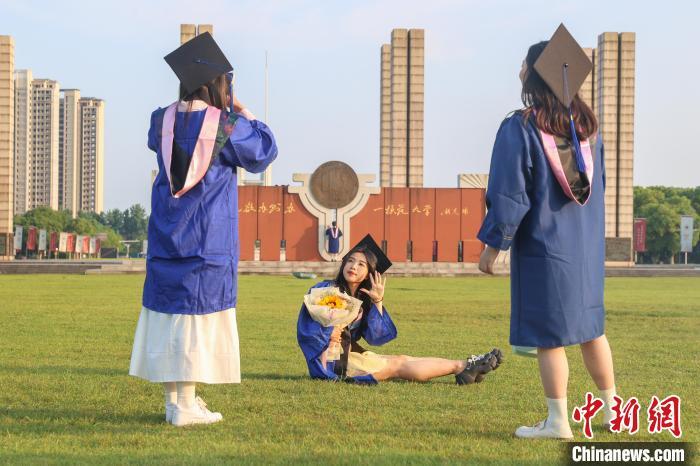 图为江西师范大学2024届毕业生在学校草坪上拍照留影。刘力鑫 摄