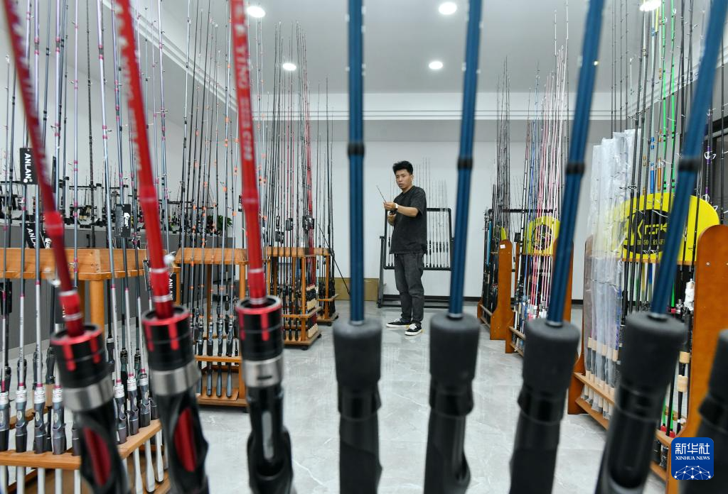 5月22日，河北省肃宁县一家鱼竿企业的工作人员在产品展厅整理鱼竿。