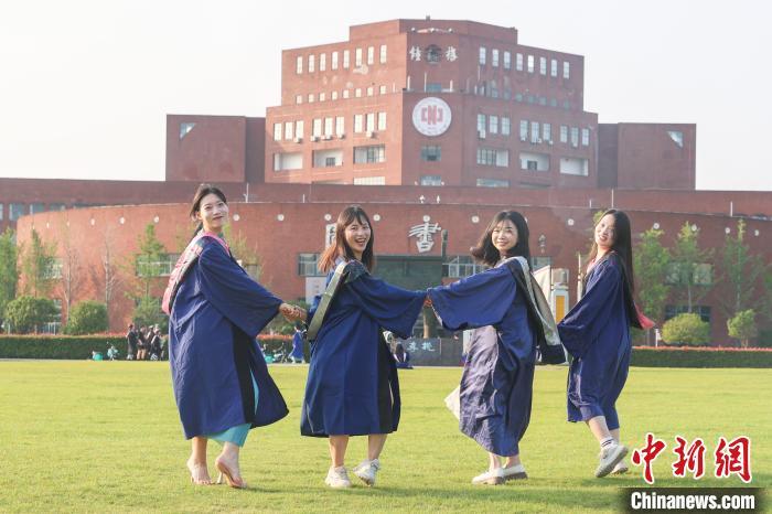 图为江西师范大学2024届毕业生身着学位服在校园内拍照留念。刘力鑫 摄