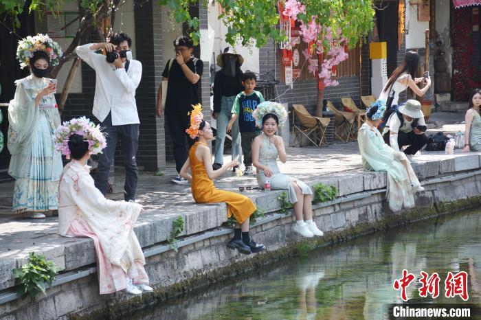 5月18日，在济南曲水亭街，随处可见“簪花姑娘”的身影。吕妍 摄