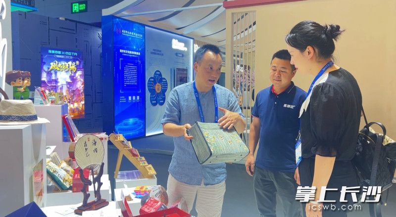 鲁松元（左）正在向观众介绍浏阳夏布文创产品。长沙晚报全媒体记者 刘俊 摄