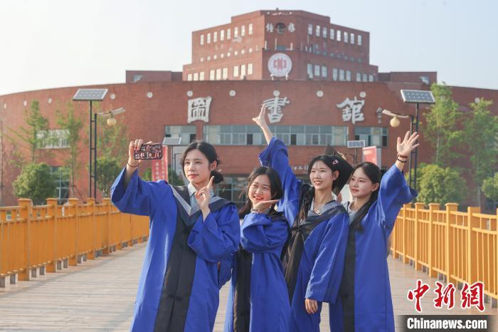 图为江西师范大学2024届毕业生在学校图书馆前自拍留念。刘力鑫 摄