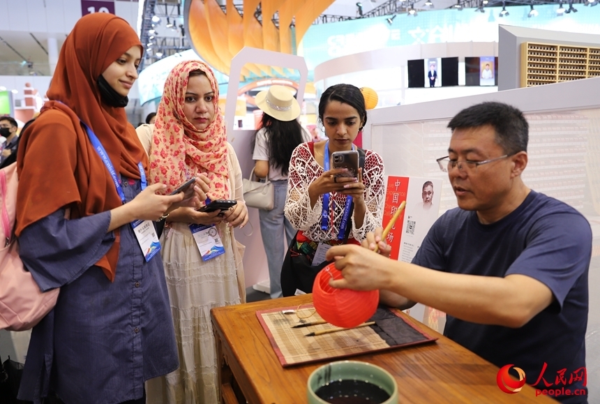 第二十届文博会上，海外观众观看书法展示　人民网　刘森君　摄