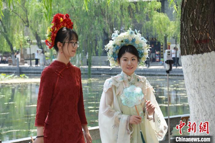 5月18日，“簪花姑娘”在街头合影留念。吕妍 摄