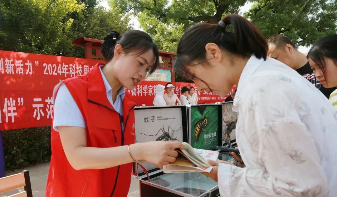 为现场群众发放科普图书《乡村振兴 农民科学素质读本I》及《农民科学素质读本 融媒体版（第二版）》