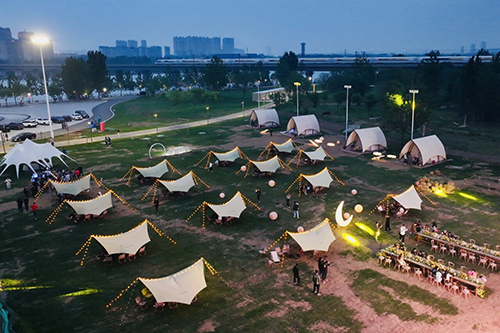 4月27日晚，游客在石家庄市滹沱河艺术生态岛星月营地享受欢乐时光。河北日报记者 李东宇摄