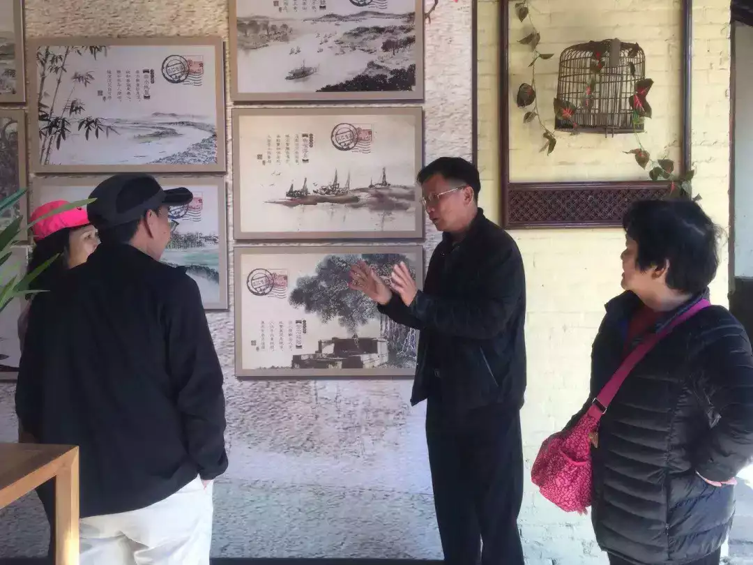 胡德赞(右二)在村史馆中为参观者讲解古灶村历史