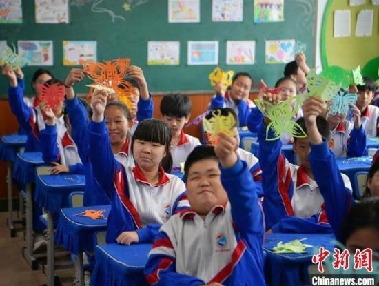 长春市腰十小学校的美术课上,学生们展示自己的剪纸作品。刘栋 摄