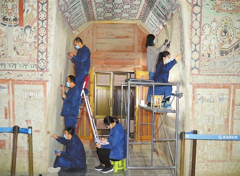 国家古代壁画与土遗址保护工程技术研究中心工作人员修复敦煌莫高窟壁画的场景