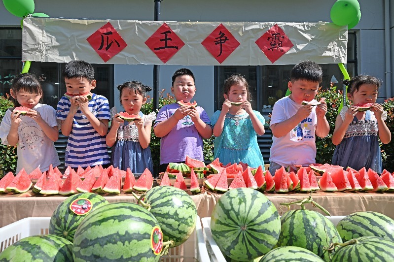 5月29日,在江西省抚州市东乡区第二幼儿园,小朋友正在大口吃西瓜,参加