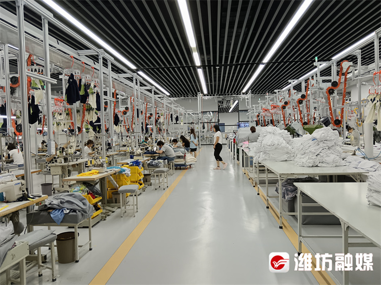 潍坊尚德服饰有限公司生产车间内，工人有序生产。