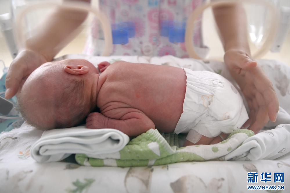 6月1日，在西安国际医学中心医院新生儿科病房，护士帮助新生儿翻身。新华社记者 刘潇 摄