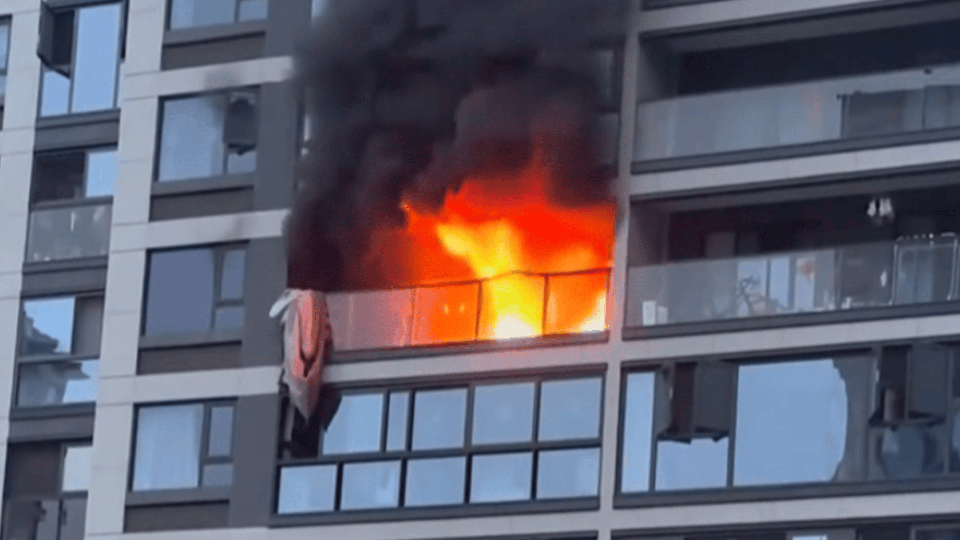 男子火灾翻阳台逃生时坠楼，多人撑被单救援，1人被砸伤