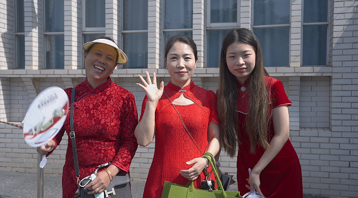 家长身着旗袍前来送考，寓意“旗开得胜”。