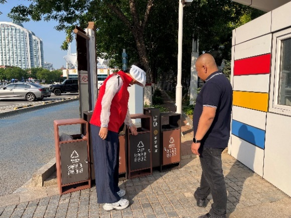 图片介绍：志愿者向游客讲解垃圾分类常识